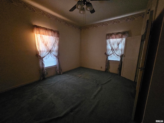 carpeted spare room with a wealth of natural light and ceiling fan