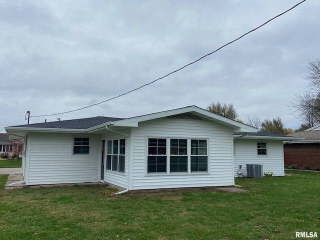 back of house with a lawn and central air condition unit