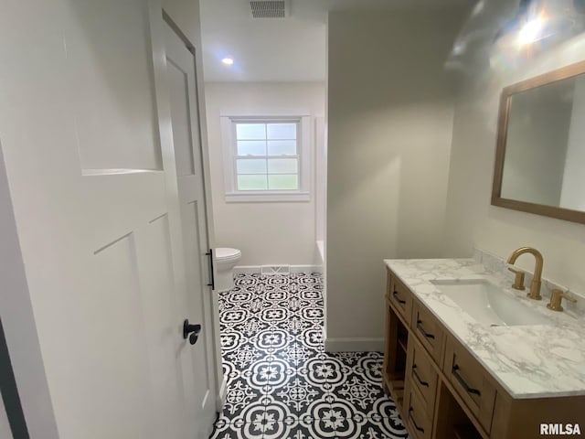 bathroom featuring a tub, tile patterned flooring, vanity, and toilet