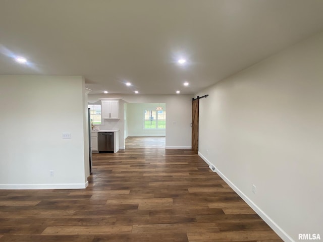 interior space with dark hardwood / wood-style flooring and a barn door