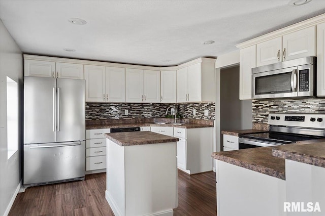 kitchen with a center island, stainless steel appliances, dark wood-type flooring, and backsplash