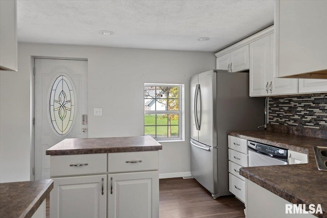 kitchen with tasteful backsplash, a textured ceiling, stainless steel appliances, dark wood-type flooring, and white cabinetry