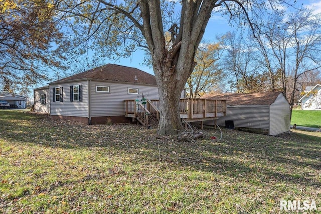 back of house featuring a lawn and a wooden deck