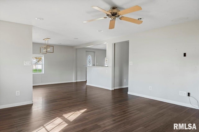 unfurnished living room with dark hardwood / wood-style flooring and ceiling fan