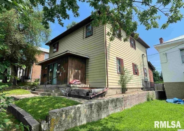 rear view of house featuring a lawn