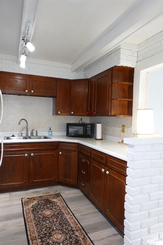 kitchen featuring tasteful backsplash, sink, and light hardwood / wood-style flooring