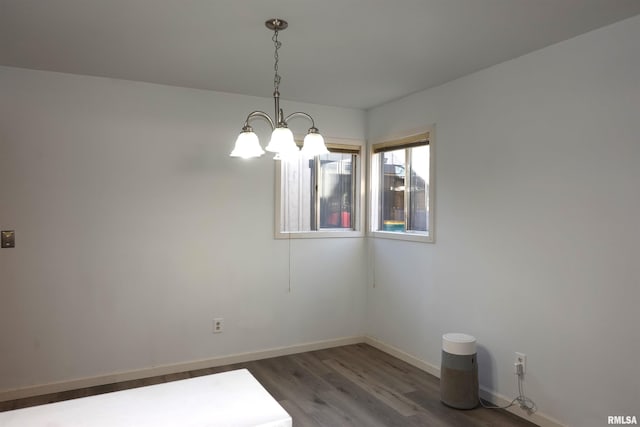 unfurnished room featuring dark hardwood / wood-style flooring and a notable chandelier