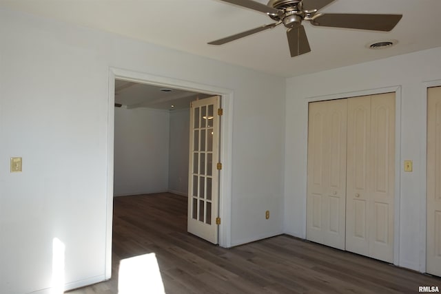 unfurnished bedroom with ceiling fan, dark hardwood / wood-style flooring, and a closet