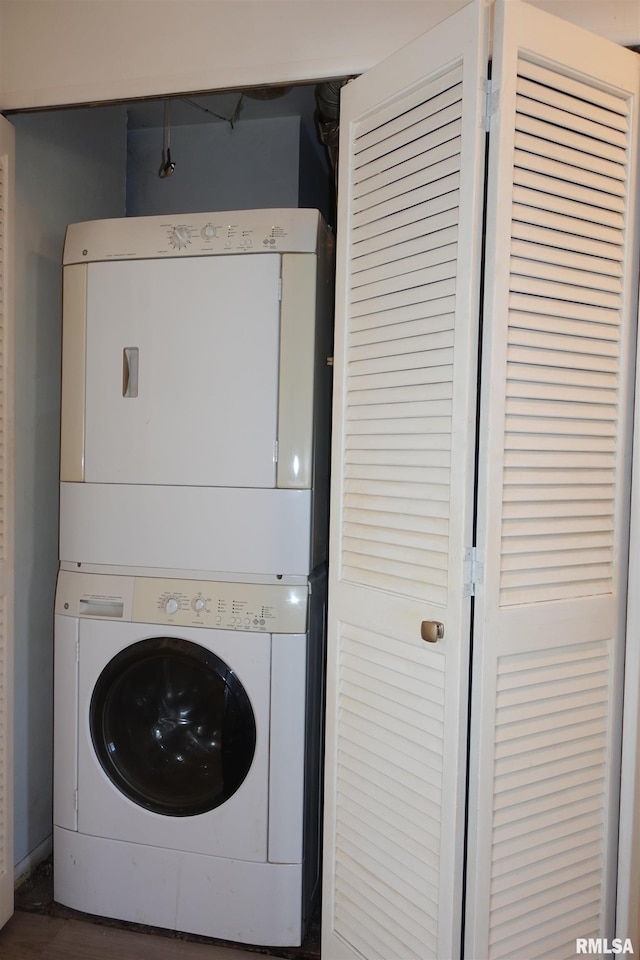 clothes washing area featuring stacked washer / dryer