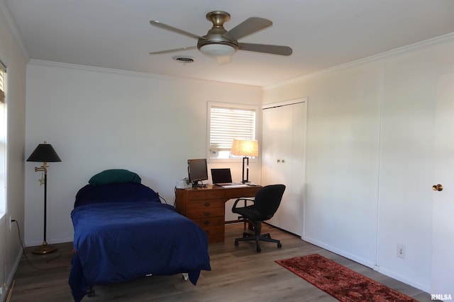 bedroom with ceiling fan, wood-type flooring, and ornamental molding