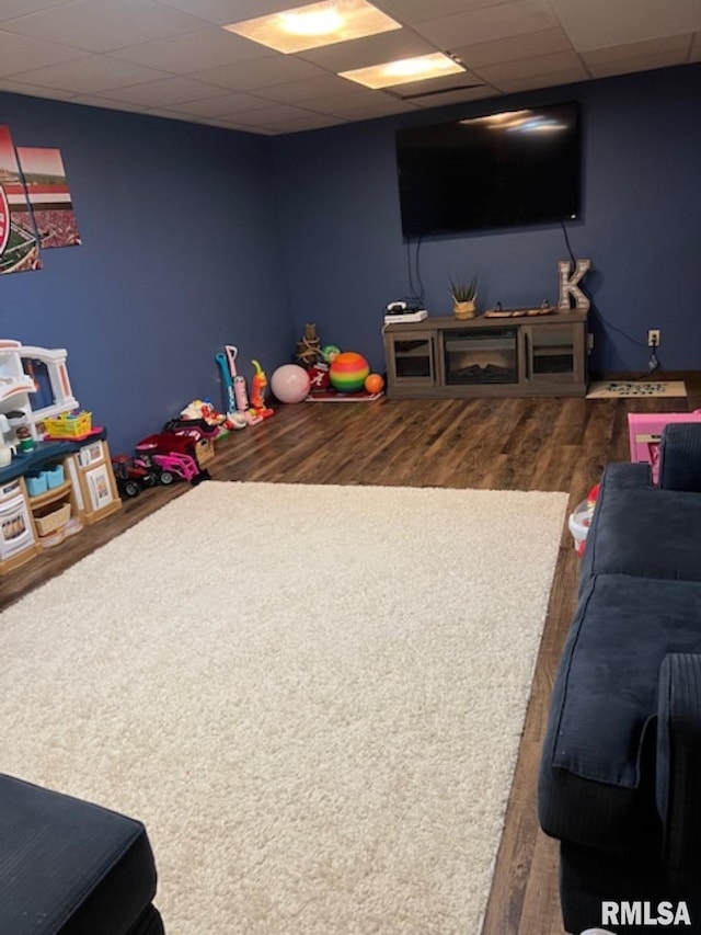 rec room with hardwood / wood-style floors and a drop ceiling