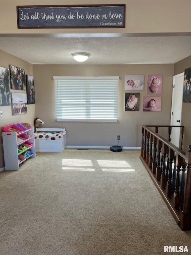 game room featuring carpet flooring and a textured ceiling