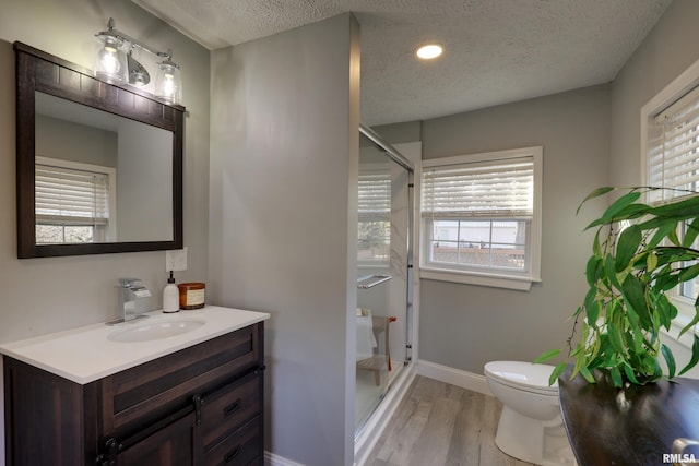 full bathroom with baseboards, a shower stall, toilet, and wood finished floors