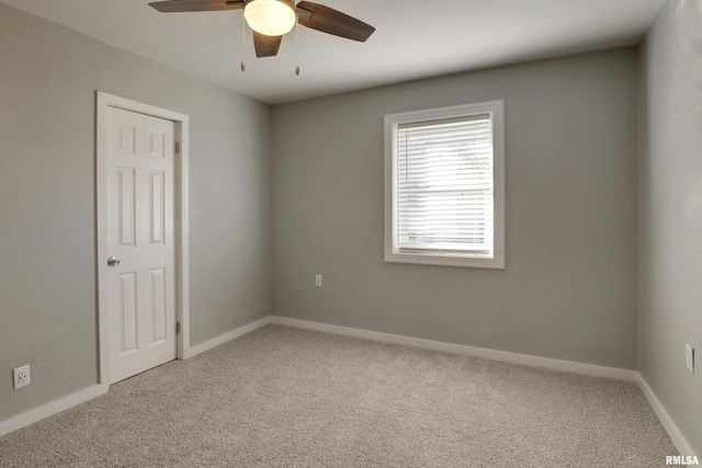 empty room with carpet floors, ceiling fan, and baseboards