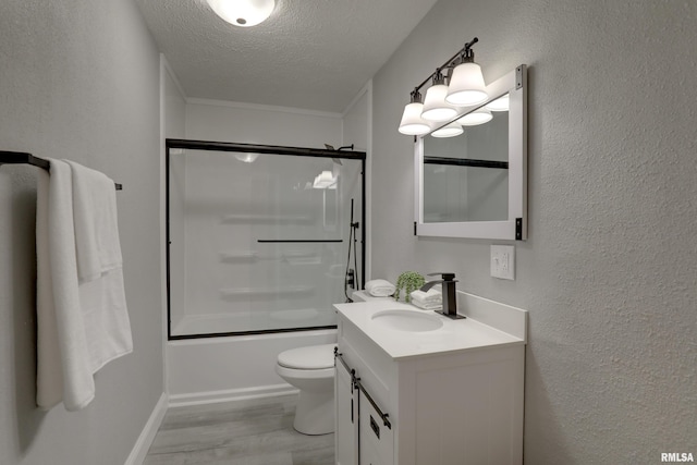 full bath with a textured ceiling, a textured wall, toilet, wood finished floors, and vanity