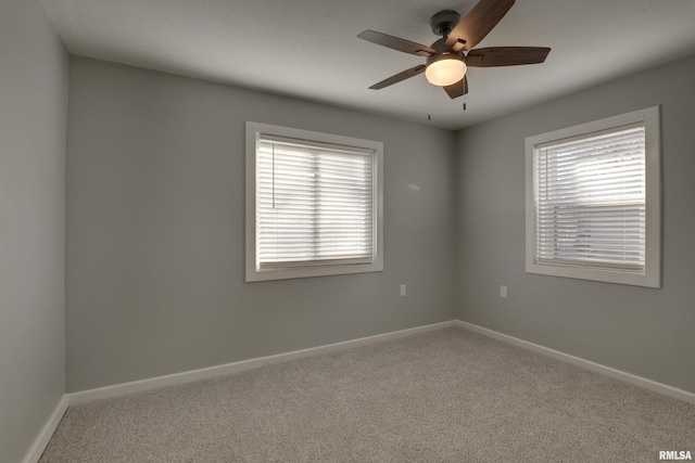 unfurnished room with a ceiling fan, carpet, and baseboards