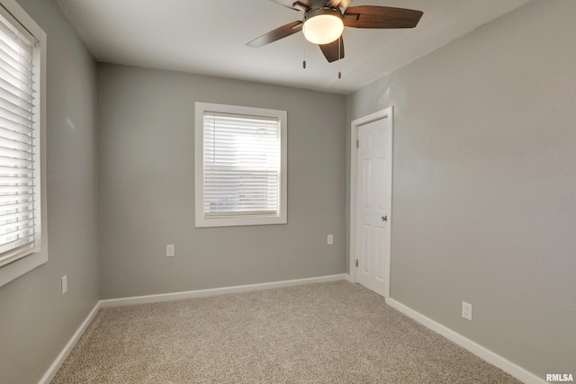 empty room with ceiling fan, carpet flooring, and baseboards