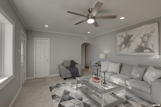 living area featuring arched walkways, crown molding, recessed lighting, ceiling fan, and baseboards