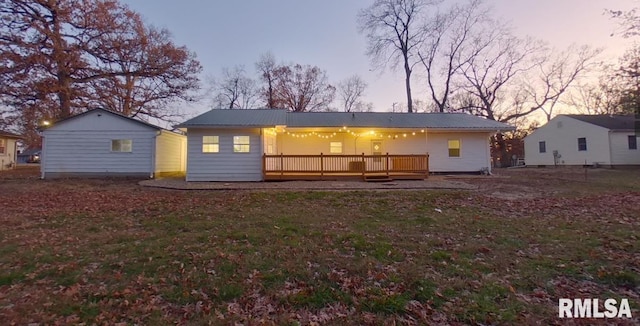 back of property at dusk with metal roof and a wooden deck