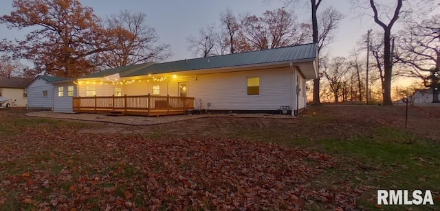 back of property featuring a deck and metal roof