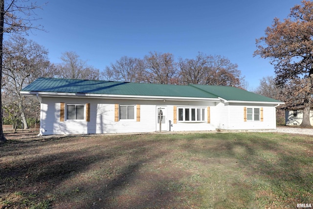 ranch-style home featuring metal roof and a front yard