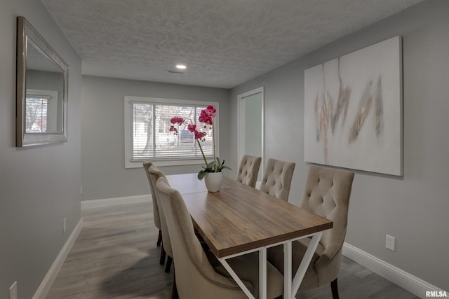 dining room with plenty of natural light, baseboards, and light wood-style flooring