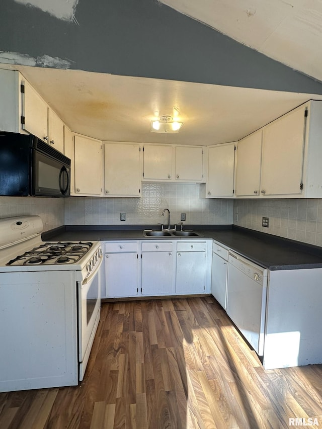 508 S Main St, Abingdon, IL 61410 - kitchen featuring white appliances, a sink, dark wood-style floors, dark countertops, and lofted ceiling