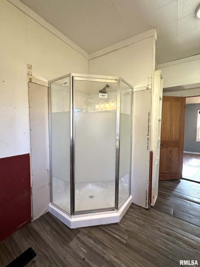 bathroom featuring hardwood / wood-style flooring and a shower with door