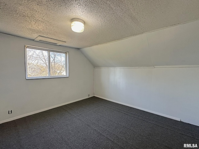 bonus room featuring a textured ceiling, dark carpet, and lofted ceiling