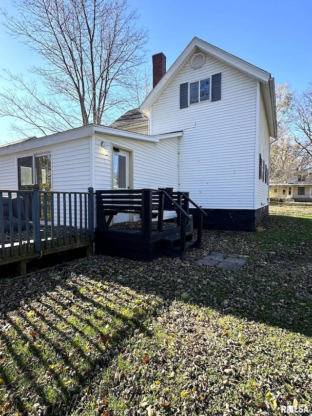 rear view of house featuring a wooden deck