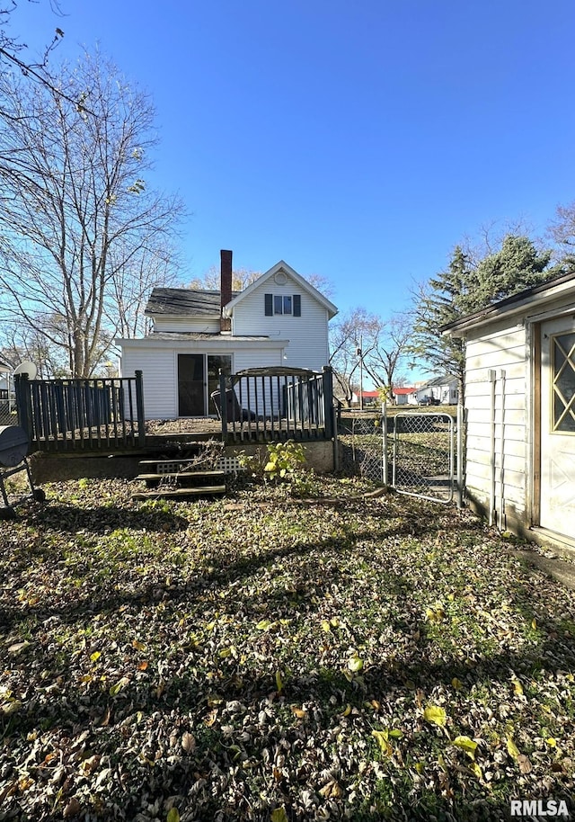 508 S Main St, Abingdon, IL 61410 - back of house featuring a wooden deck, a chimney, and a gate