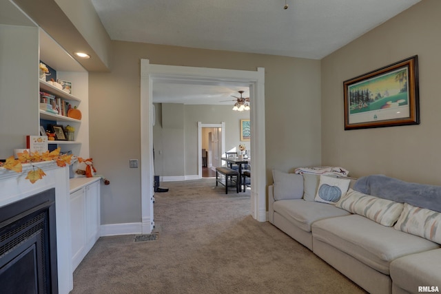 carpeted living room featuring ceiling fan