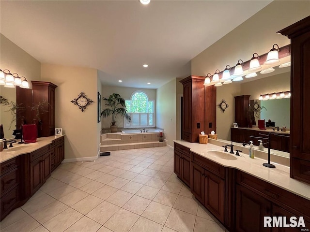 bathroom with vanity, tile patterned flooring, and a relaxing tiled tub