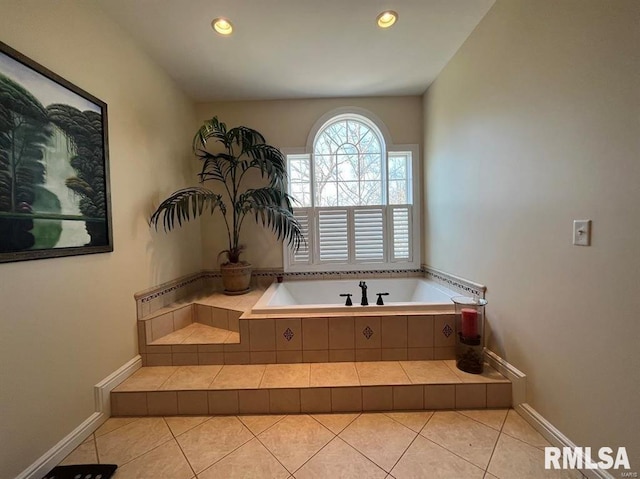 bathroom with tiled bath and tile patterned flooring