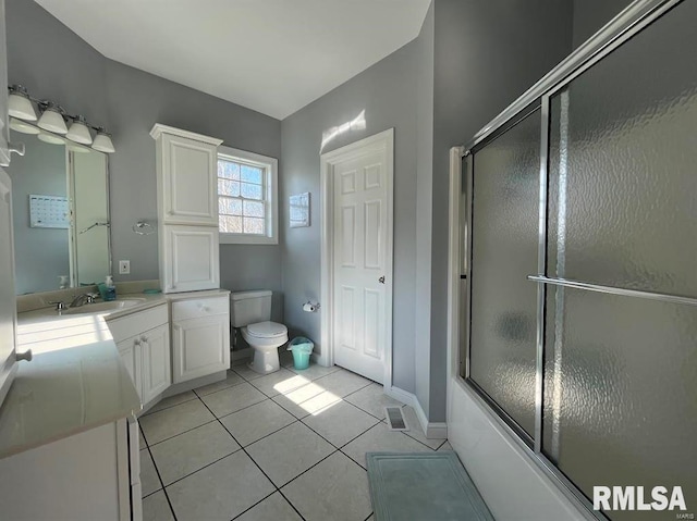 full bathroom featuring toilet, vanity, tile patterned floors, and shower / bath combination with glass door