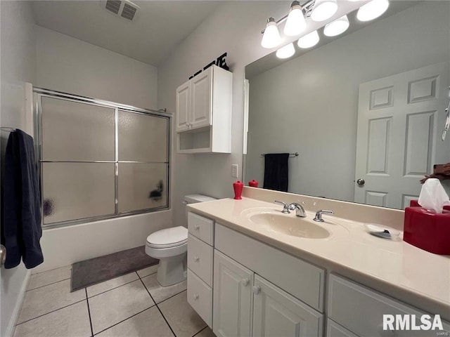 full bathroom with tile patterned floors, shower / bath combination with glass door, vanity, and toilet