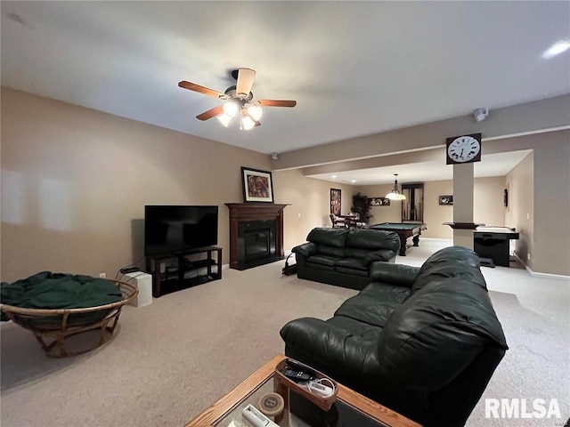 carpeted living room with ceiling fan, a fireplace, and pool table