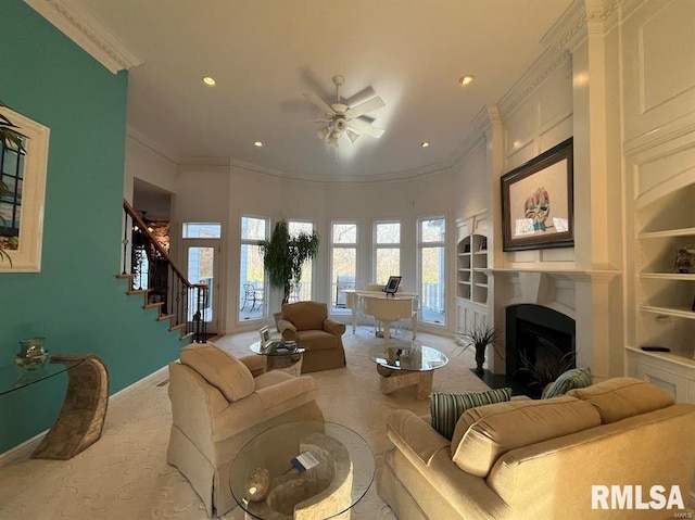 living room featuring light carpet, built in features, ceiling fan, and ornamental molding