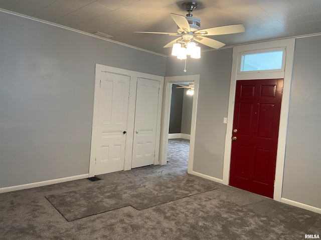 entrance foyer with ceiling fan, carpet flooring, and ornamental molding