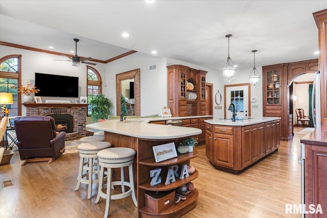 kitchen featuring hanging light fixtures, light hardwood / wood-style floors, ceiling fan, and a healthy amount of sunlight