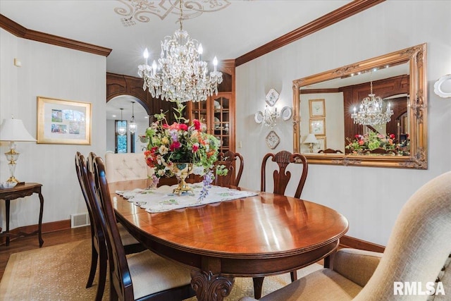 dining area with crown molding, a chandelier, and hardwood / wood-style flooring