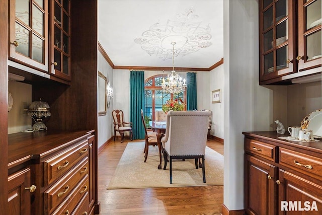 dining space featuring a chandelier, crown molding, and light hardwood / wood-style flooring