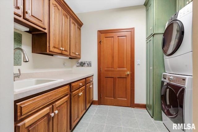 clothes washing area with sink, cabinets, and stacked washer / drying machine