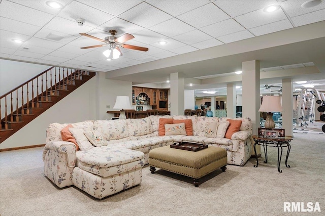 living room with a paneled ceiling, ceiling fan, and light carpet