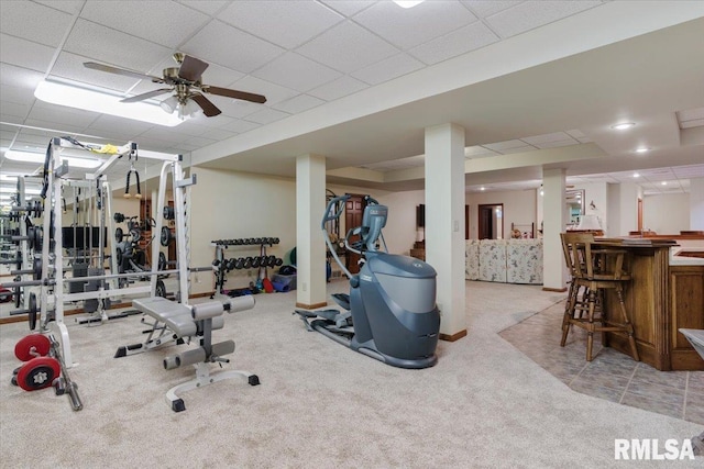 workout room featuring light carpet, a drop ceiling, and ceiling fan