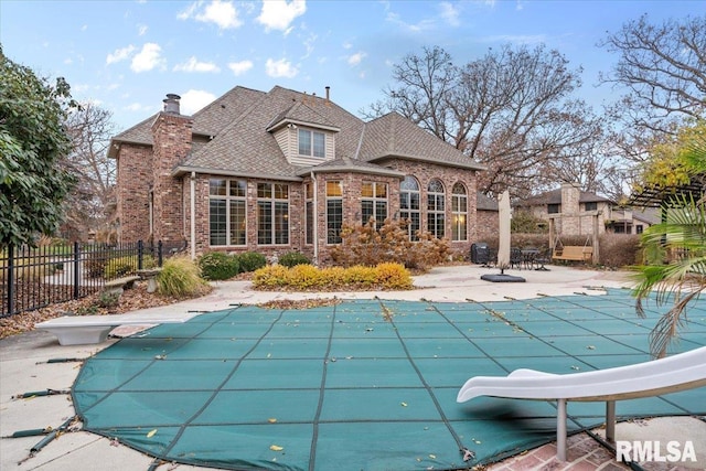 view of swimming pool featuring a diving board, a patio area, and a water slide