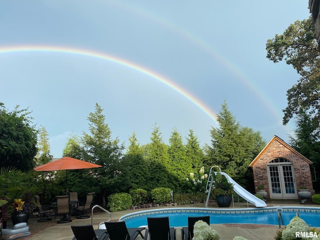 view of pool with a patio area and a water slide