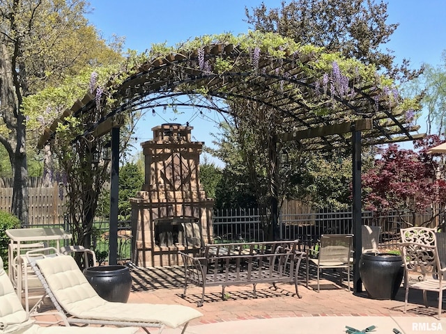 view of gate with a patio area and exterior fireplace