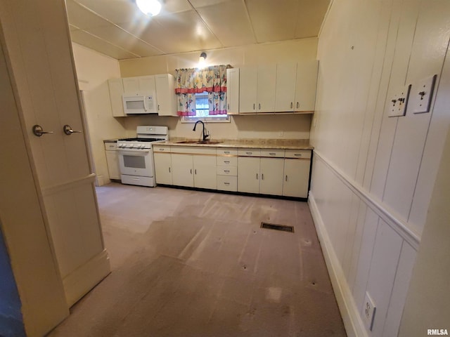 kitchen with light carpet, white appliances, white cabinetry, and sink