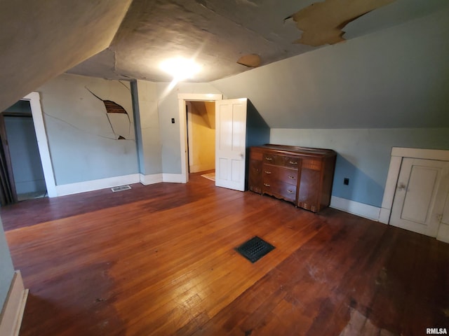 additional living space featuring lofted ceiling and dark wood-type flooring